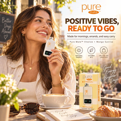 Woman holding Pure Mate Vitalize Mango Sunrise zero nicotine diffuser at a sunny outdoor cafe